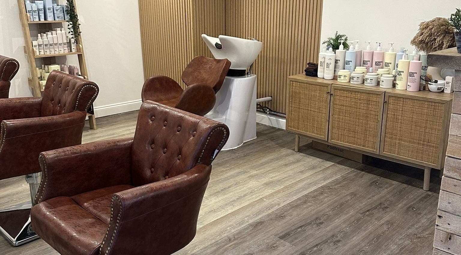 Stylish salon interior at C.B Colour, Portishead, England, GB with leather chairs and beauty products.