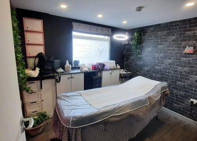Интерьер салона Anastasiia’s Lashes, Camborne, England, GB - уютная комната с массажным столом и зеленью.