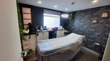 Интерьер салона Anastasiia’s Lashes, Camborne, England, GB - уютная комната с массажным столом и зеленью.