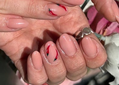 Stylish nail design at Beauty Style Salon in Merstham, England, GB showcases elegant pink polish with red accents.