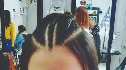 Estilista trenzando cabello en armonia y belleza, CO, mostrando detalle de peinado sofisticado.