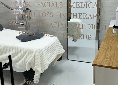 Relaxing treatment room at Saona Beauty Clinic, Pembroke Pines, Florida, US, showcasing plush bed and modern decor.