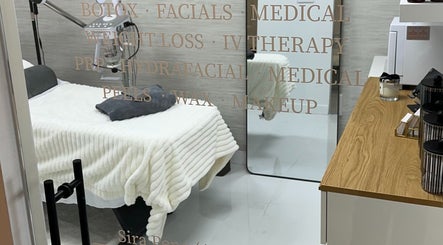 Treatment room at Saona Beauty Clinic in Pembroke Pines, Florida, US, featuring a bed and skincare equipment.