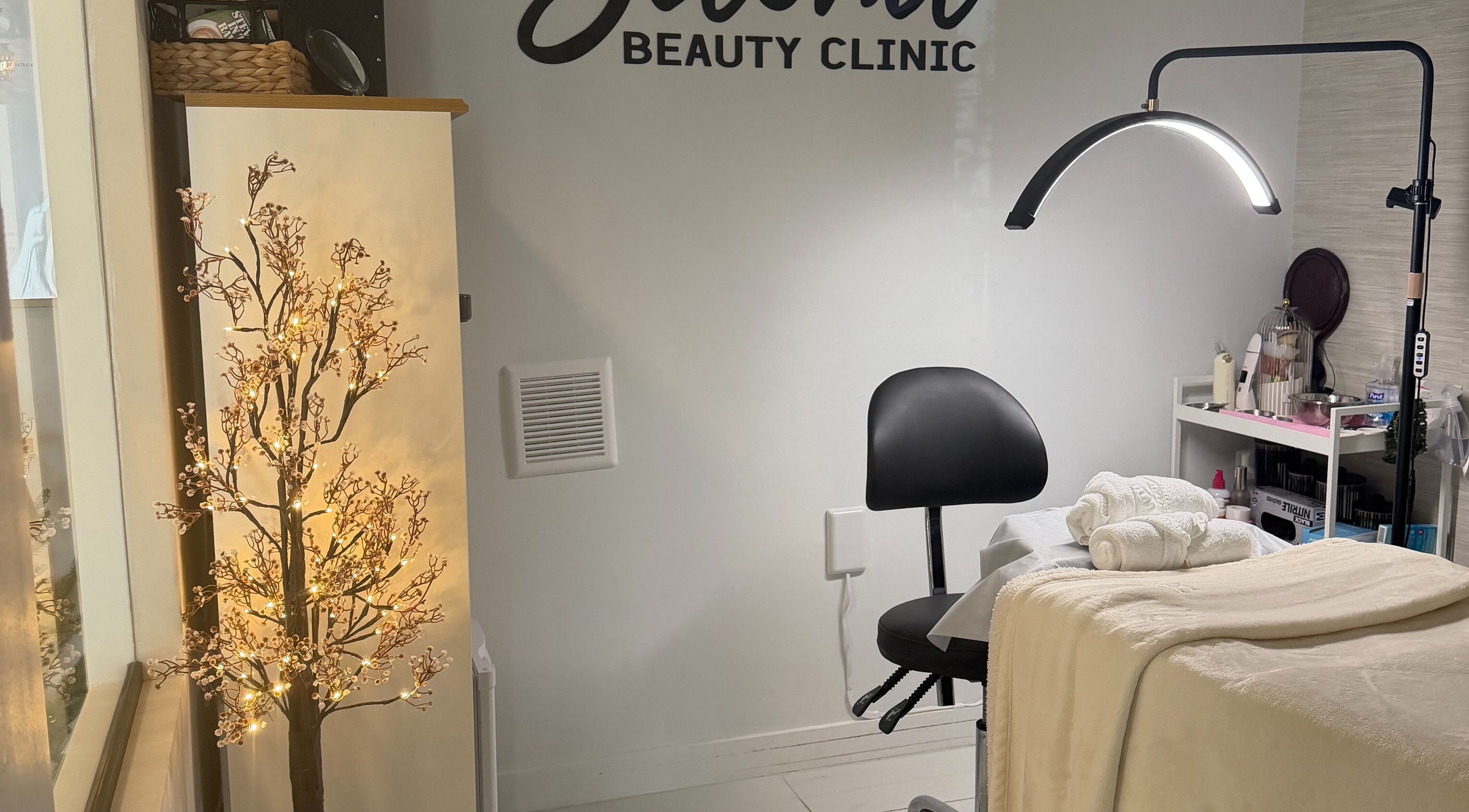 Relaxing treatment room at Saona Beauty Clinic in Pembroke Pines, Florida, US with cozy decor and lighting.