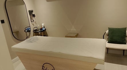 غرفة علاج فاخرة في Relax Care العناية بالراحة الدمام، المنطقة الشرقية، SA تضم سرير تدليك ومرايا.