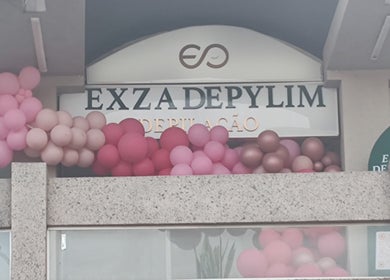Fachada do Exza Depylim Se com balões rosa em Minas Gerais, BR.