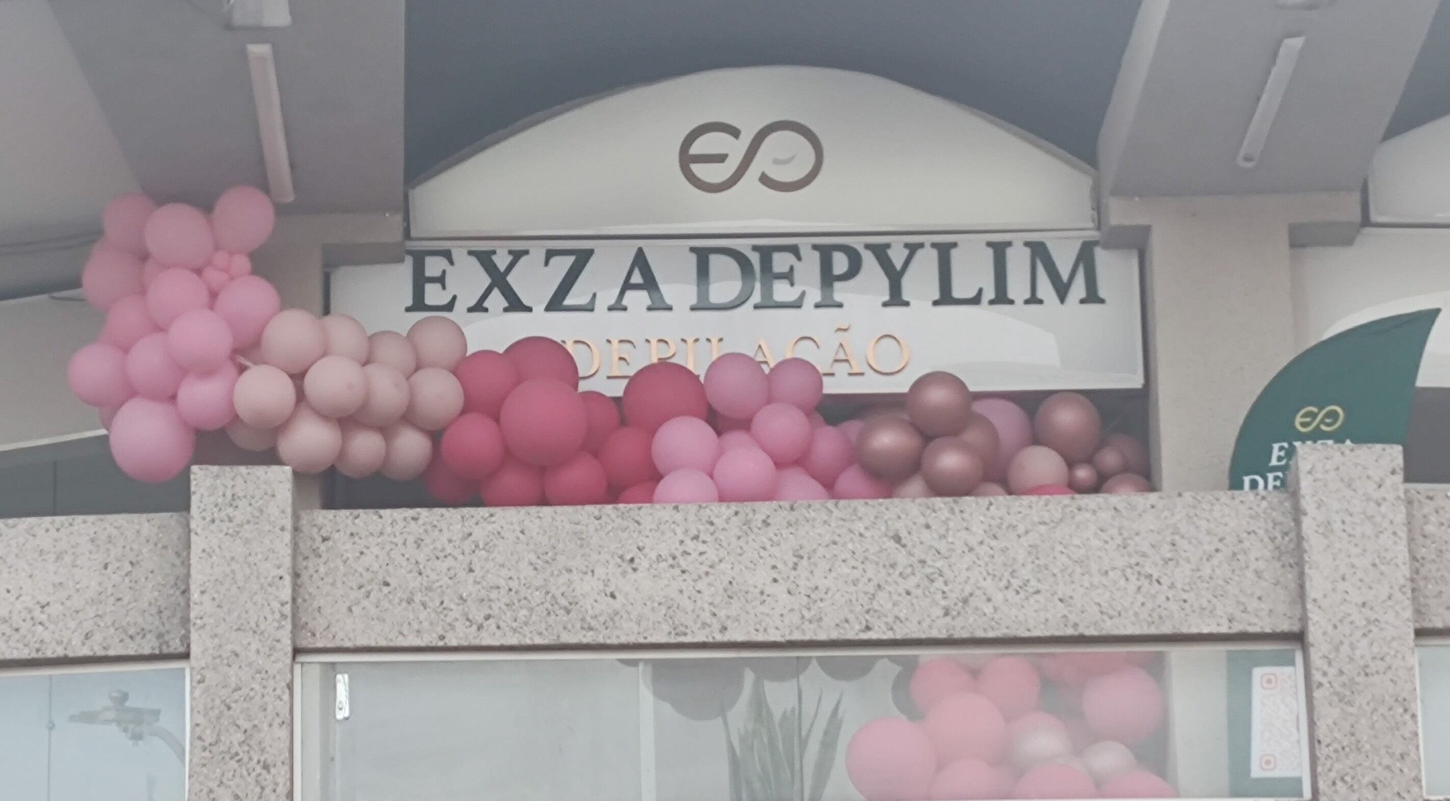 Fachada do Exza Depylim Se com balões rosa em Minas Gerais, BR.