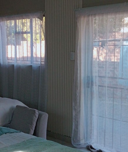 Tranquil bedroom at Nomngoma Royal Spa, Emalahleni, Mpumalanga, ZA, featuring soft lighting and elegant decor.