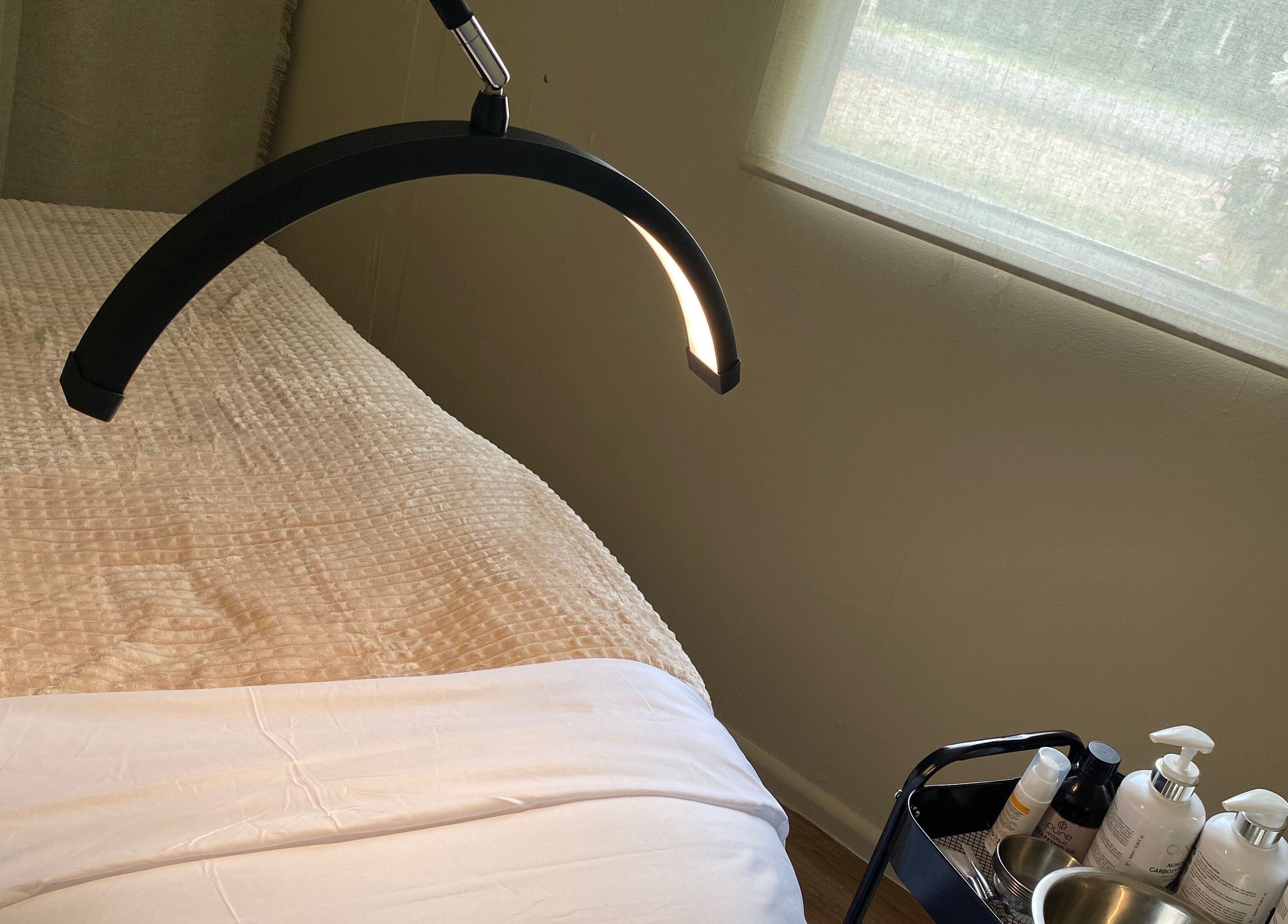 Relaxing treatment room at Enrich Treatments, Saffron Walden, England, GB with a massage table and products.