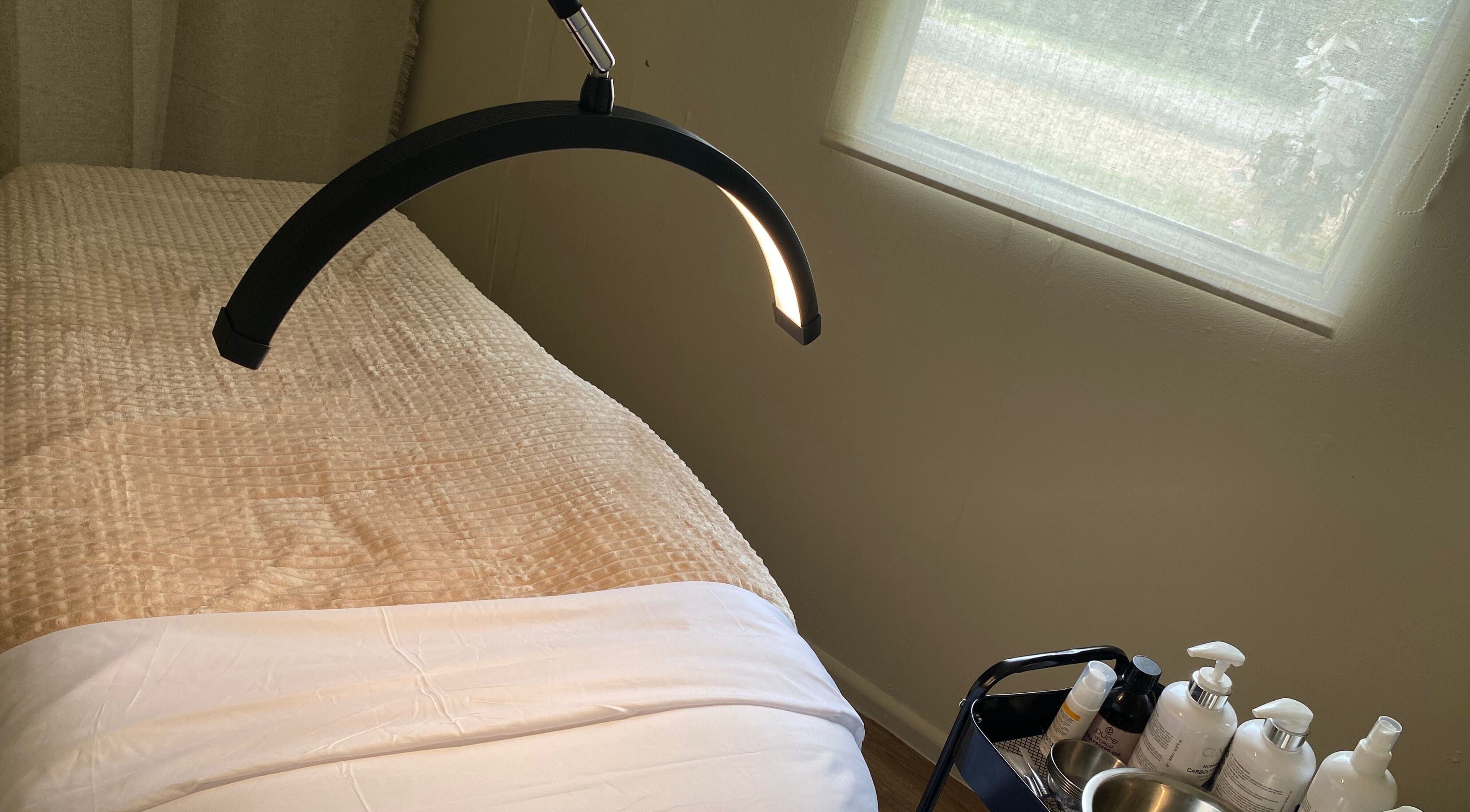 Relaxing treatment room at Enrich Treatments, Saffron Walden, England, GB with a massage table and products.