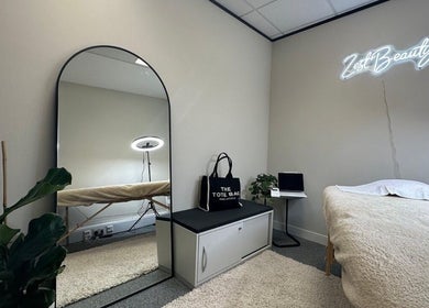 Tranquil beauty room at MSKN in Manchester, England, GB, featuring a mirror, plants, and cozy treatment bed.