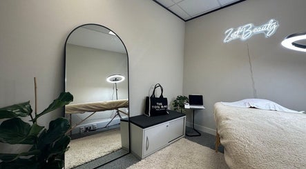 Tranquil beauty room at MSKN in Manchester, England, GB, featuring a mirror, plants, and cozy treatment bed.