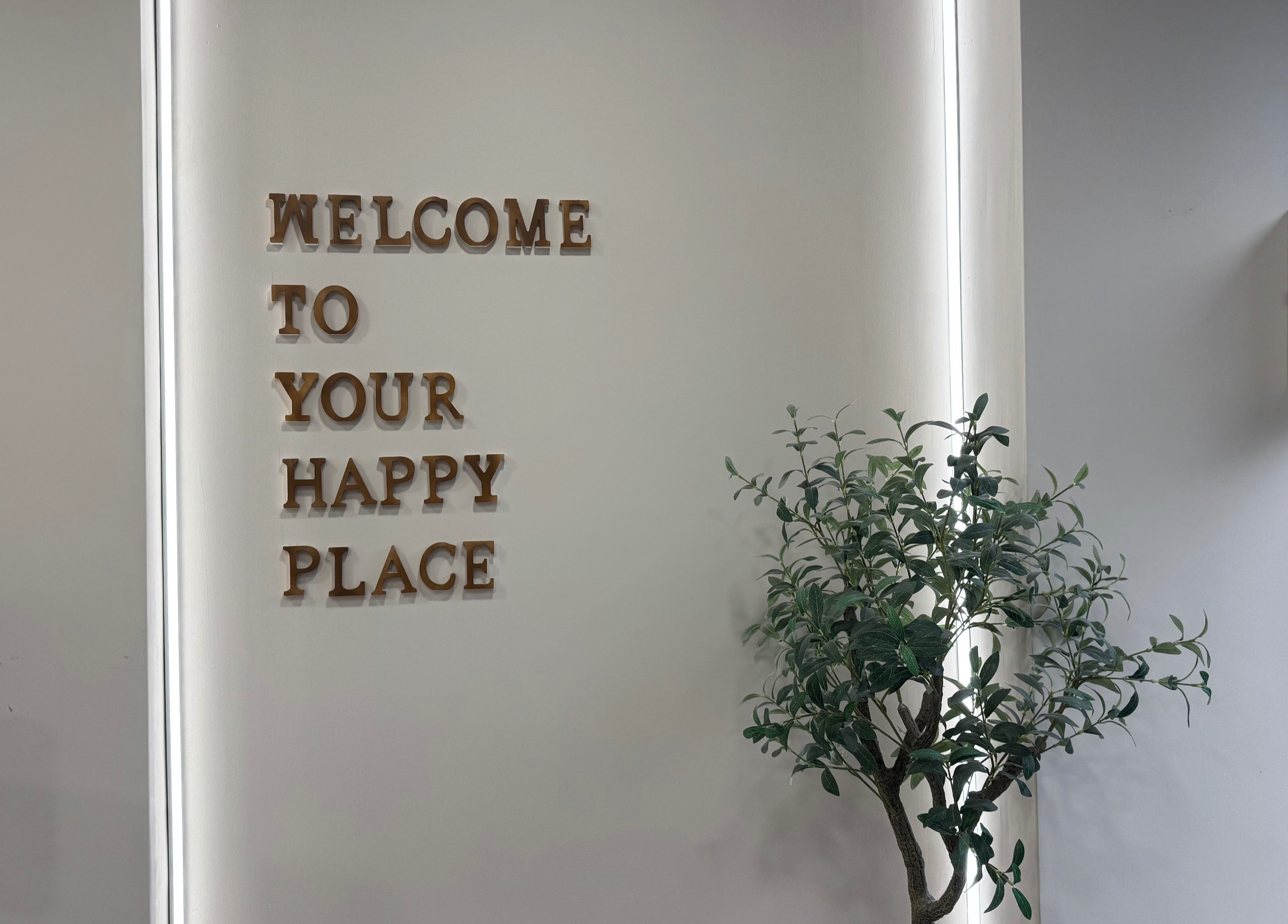 Welcome sign in MSKN, Manchester, England, GB near greenery adds inviting vibe.