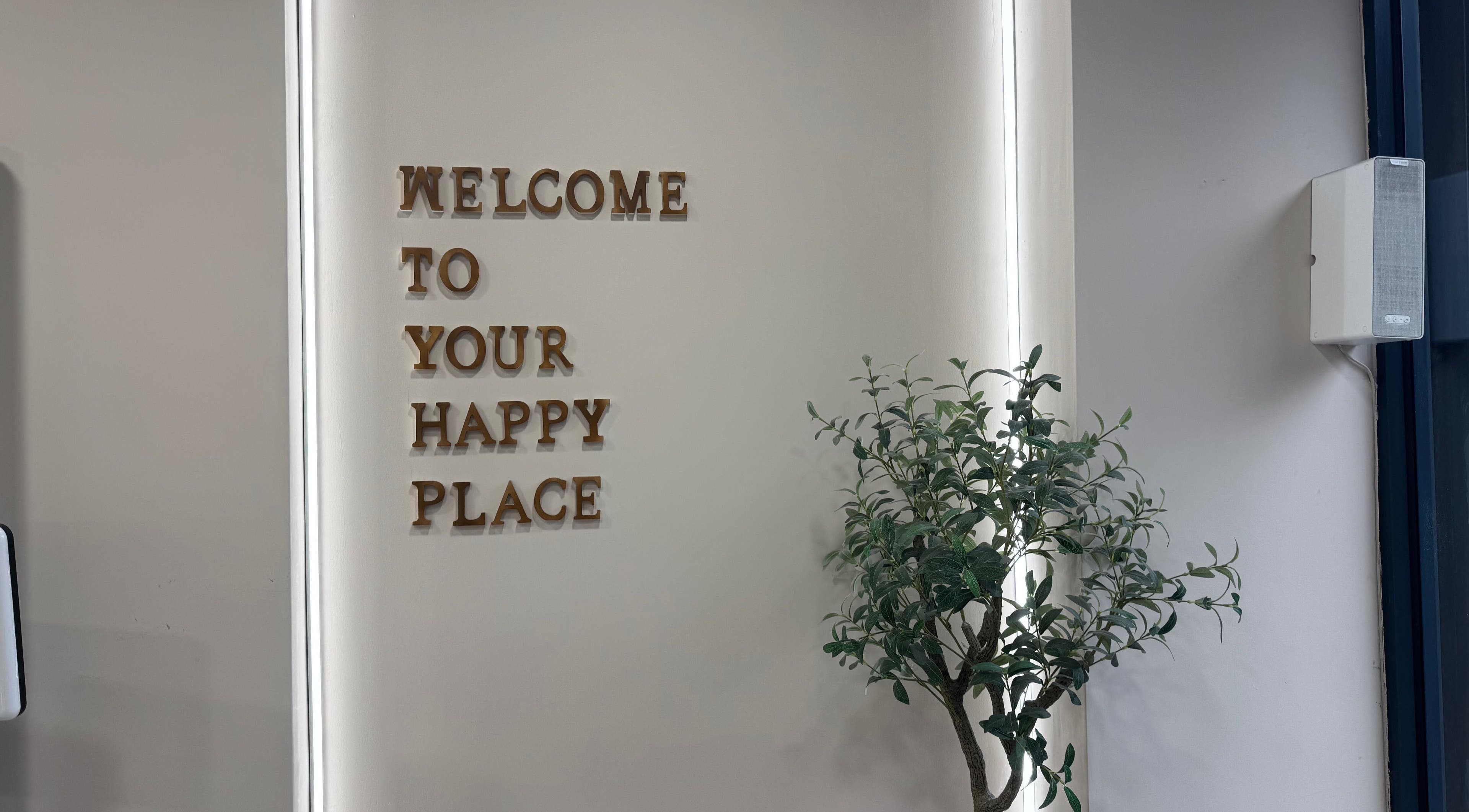 Welcome sign in MSKN, Manchester, England, GB near greenery adds inviting vibe.