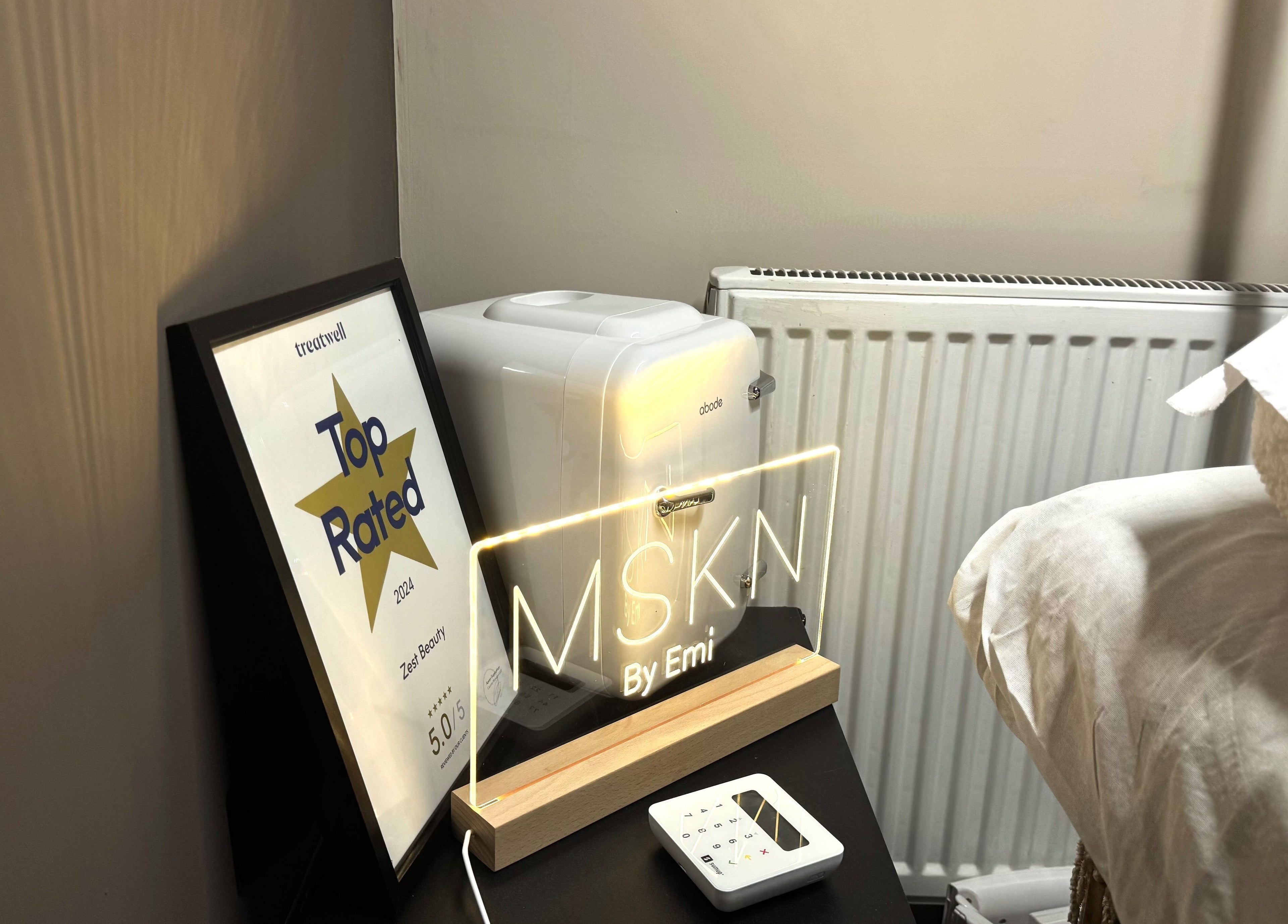 MSKN award corner in Manchester, England, GB featuring 'Top Rated' certificate and glowing sign.