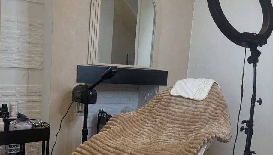 Cozy treatment room at RAE - Shade Salon, Worsley, England, GB, featuring plush bed and soft lighting.
