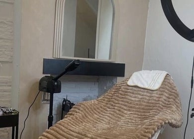 Cozy treatment room at RAE - Shade Salon, Worsley, England, GB, featuring plush bed and soft lighting.