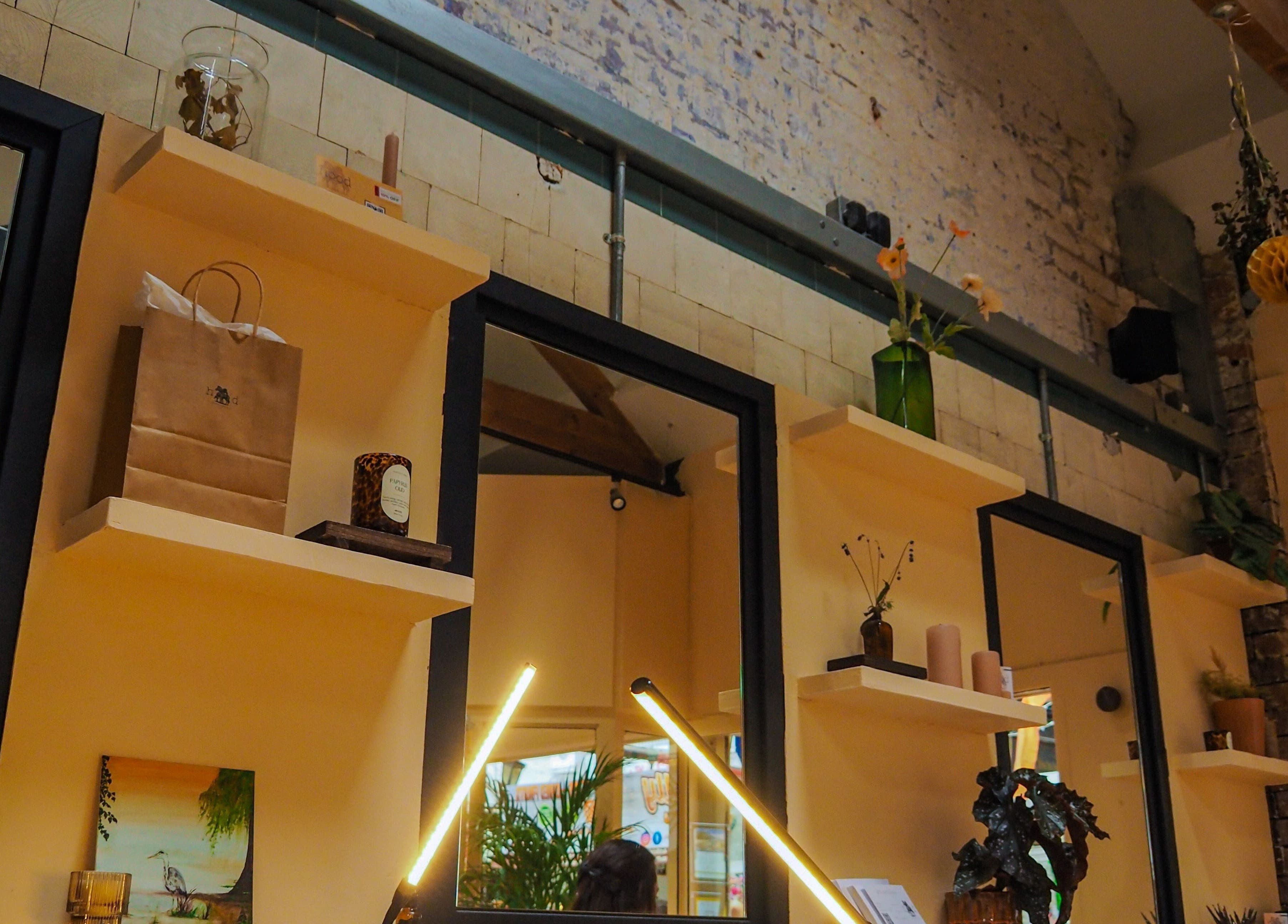 Stylish interior shelves at Hood Beauty Studio in Dublin, County Dublin, IE with decor and mirrors.