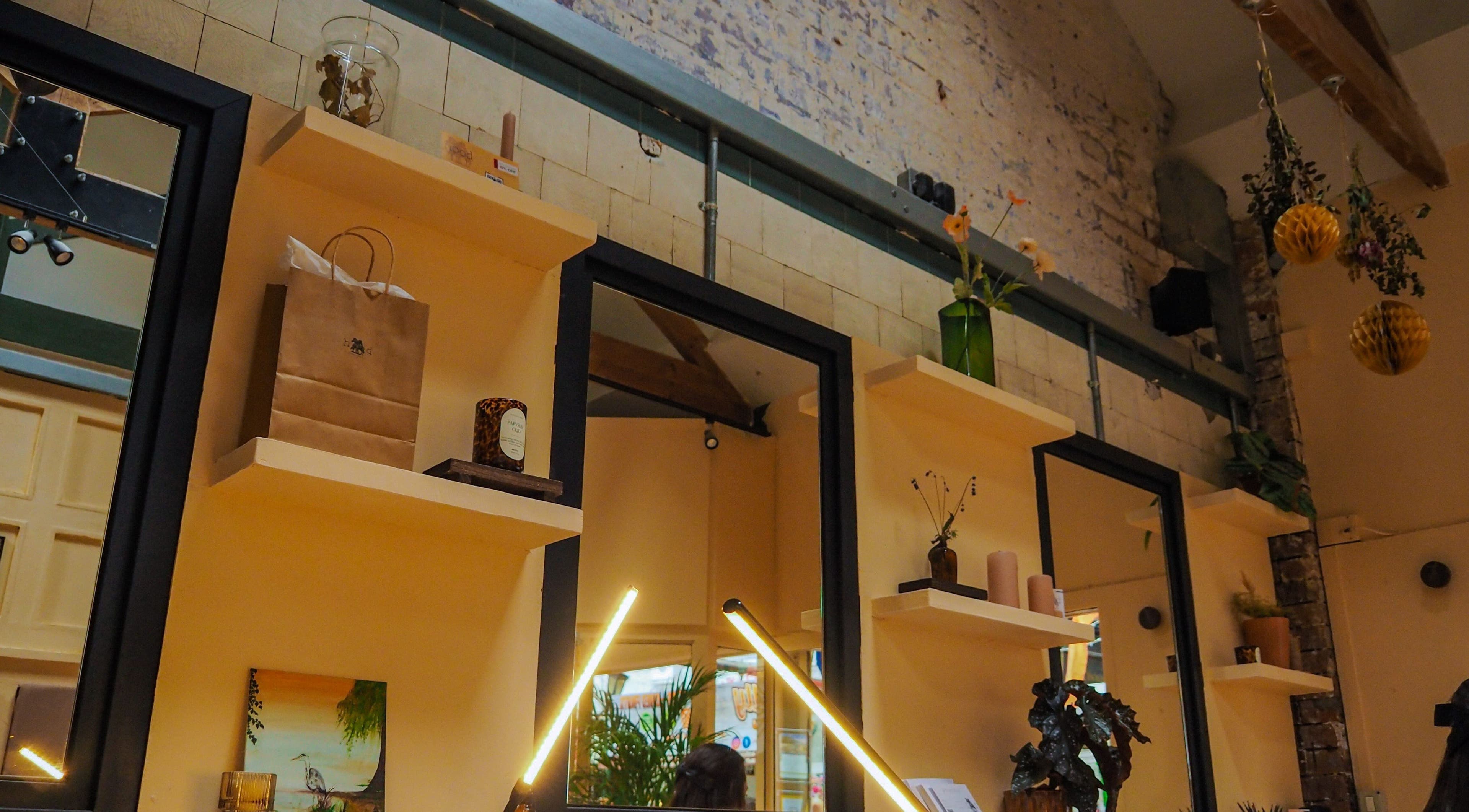 Stylish interior shelves at Hood Beauty Studio in Dublin, County Dublin, IE with decor and mirrors.
