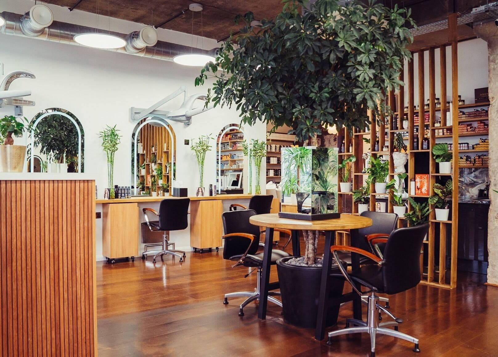 Modern beauty salon interior at ADEM, London, England, GB with stylish decor and lush greenery.