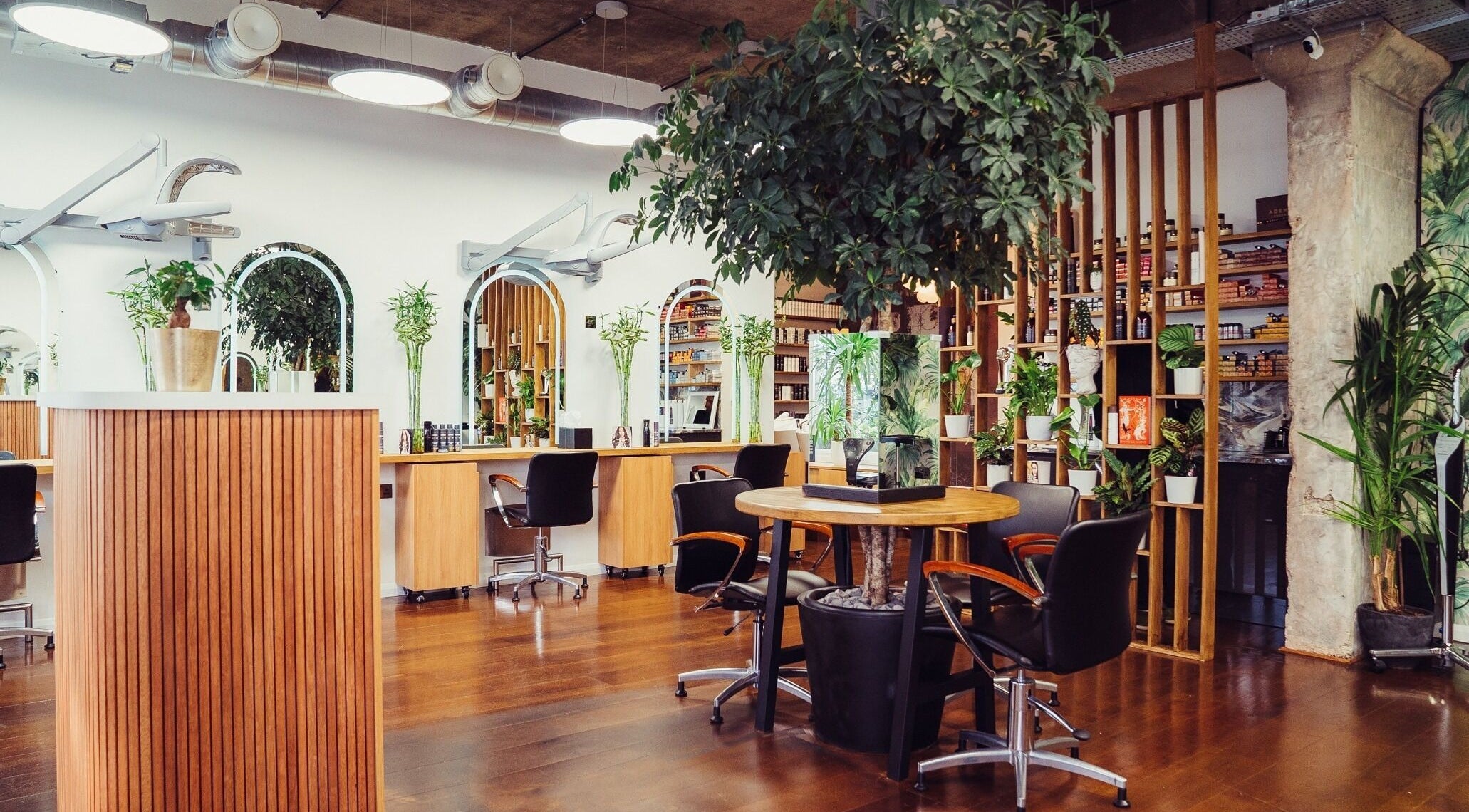 Modern beauty salon interior at ADEM, London, England, GB with stylish decor and lush greenery.