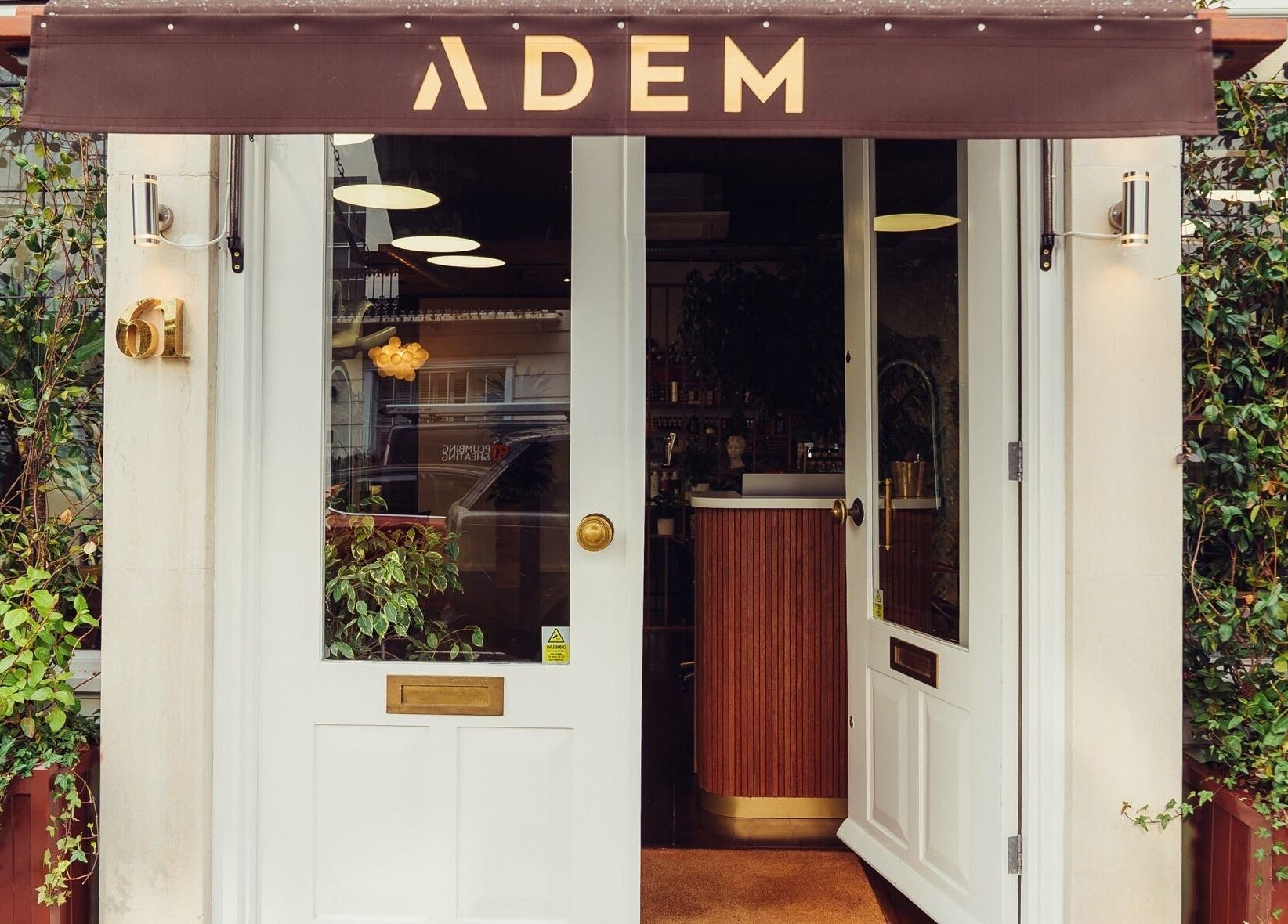 Entrance to ADEM salon with elegant door and green vine decor, located in London, England, GB.