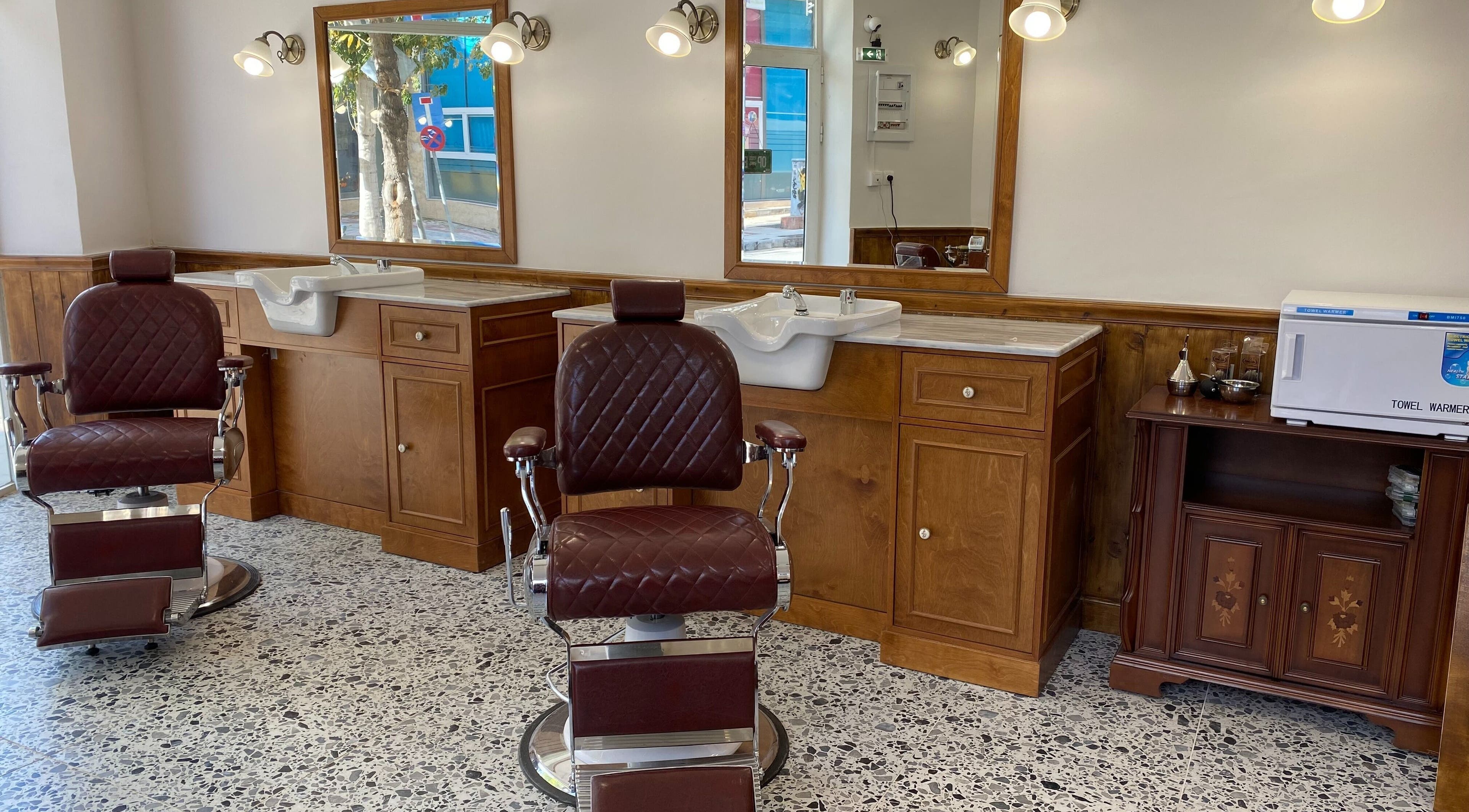 Κλασική καρέκλα κουρέα σε σαλόνι του 'Στου Κουρέα', Εύοσμος, GR, με ξύλινες λεπτομέρειες.