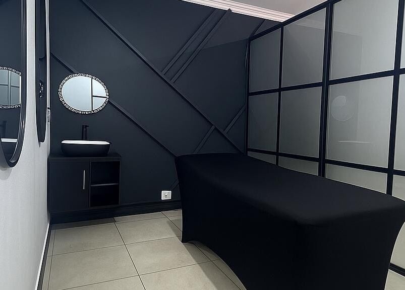 Sleek treatment room at Glow Up Beauty Salon, Pretoria, Gauteng, ZA with mirrors and a plush treatment table.