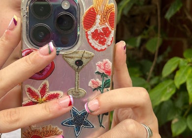 Colorful nail art with floral phone case at Steel and Polish Nails, Loxley, England, GB.