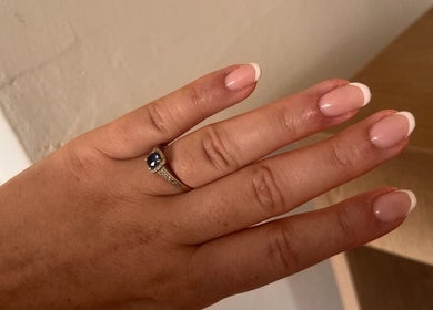 Elegant French manicure at Steel and Polish Nails, Loxley, England. Close-up of hand with ring.