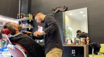 Κουρέας περιποιείται πελάτη στο Barber Corner, Βύρωνας, GR. Άνετη και κομψή ατμόσφαιρα για μοναδική εμπειρία.