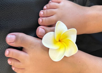 Pés com esmalte rosa claro e flor no centro na Madmoiselle Beleza e Estética, Lagos, Faro, PT.