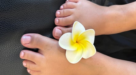 Pés com esmalte rosa claro e flor no centro na Madmoiselle Beleza e Estética, Lagos, Faro, PT.