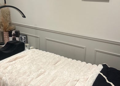 Cozy treatment bed at Blushed Beauty by Amelia, Wormegay, England, GB. Elegant decor creates a serene atmosphere.