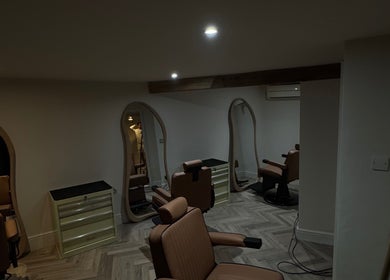 Cozy interior of Reset Barbers, a stylish barber shop in Beccles, England, GB with modern chairs and mirrors.