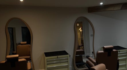 Chic interior of Reset Barbers in Beccles, England, GB, featuring stylish salon chairs and wavy mirrors.
