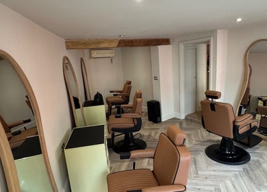 Modern barber chairs and mirrors at Reset Barbers in Beccles, England, GB, showcasing a sleek interior.