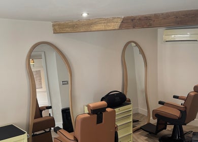 Interior of Reset Barbers in Beccles, England featuring modern barber chairs and stylish mirrors.