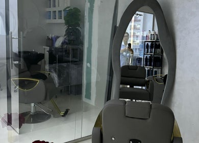 Интерьер салона Sadoo Ladies Beauty Center в Абу-Даби, AE с современными креслами и зеркалом.