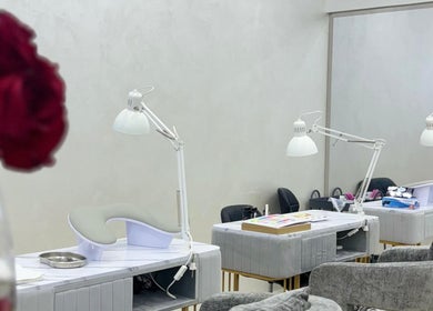 Маникюрные столы в Sadoo Ladies Beauty Center, Абу-Даби, AE, с букетом роз на переднем плане.