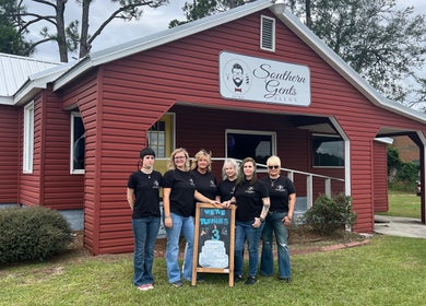 Team posing outside Southern Gents salon in Swainsboro, Georgia, US, celebrating their third anniversary.