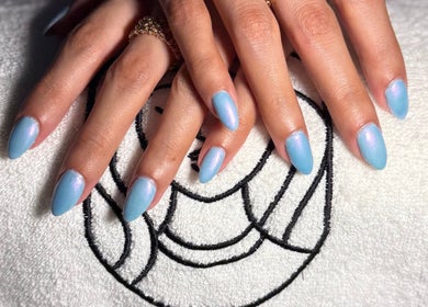 Elegant blue manicure showcased at Dakkat Athiyah in Riyadh, Riyadh Province, SA on a stylish towel.