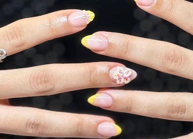 Stylish nail art with yellow tips and floral designs at Venus Care, Riyadh, Riyadh Province, SA.