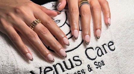 Polka dot nail art at Venus Care in Riyadh, Riyadh Province, SA, showcasing elegant hands on a branded towel.