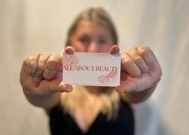 Person holding All About Beauty Salon card in Eagan, Minnesota, US.