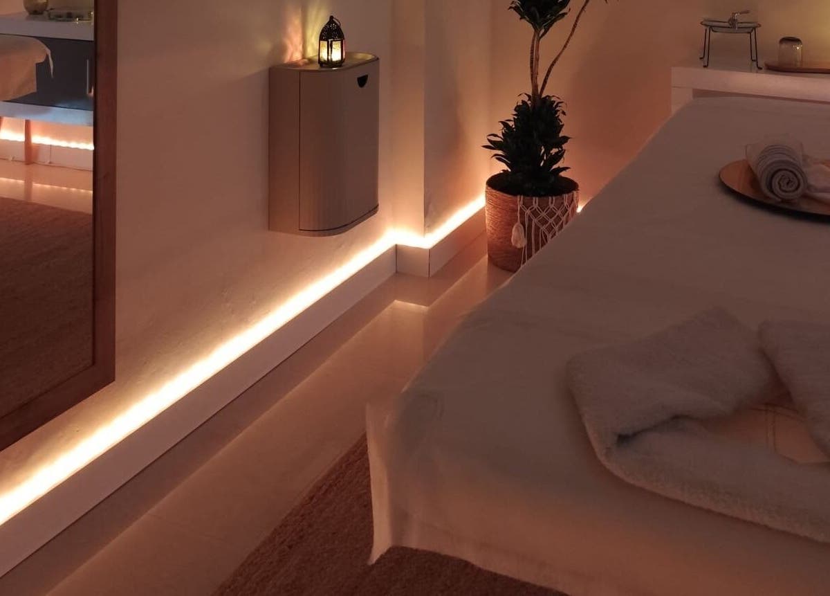 Sala de masaje Ámbar Masajes, València, Comunidad Valenciana, ES, con iluminación suave y toallas blancas.