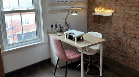 Charming nail station at Nails By Kay, Bromsgrove, England, GB featuring comfortable seating and a rustic brick wall.