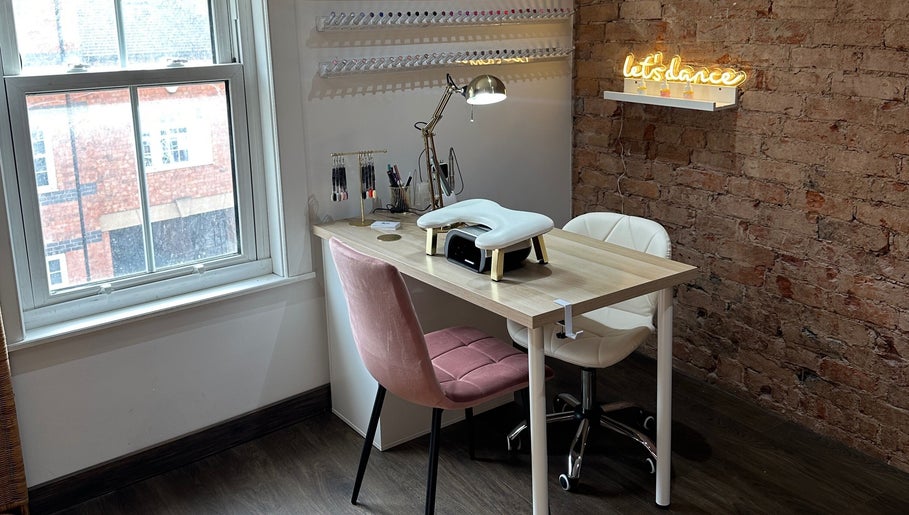 Nail station at Nails By Kay, Bromsgrove, England, GB with pink chair and rustic brick decor.