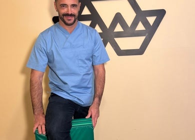 Therapist at Porto Massage Studio in Porto, Porto, PT, wearing blue uniform in relaxed setting.