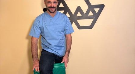 Therapist at Porto Massage Studio in Porto, Porto, PT, wearing blue uniform in relaxed setting.